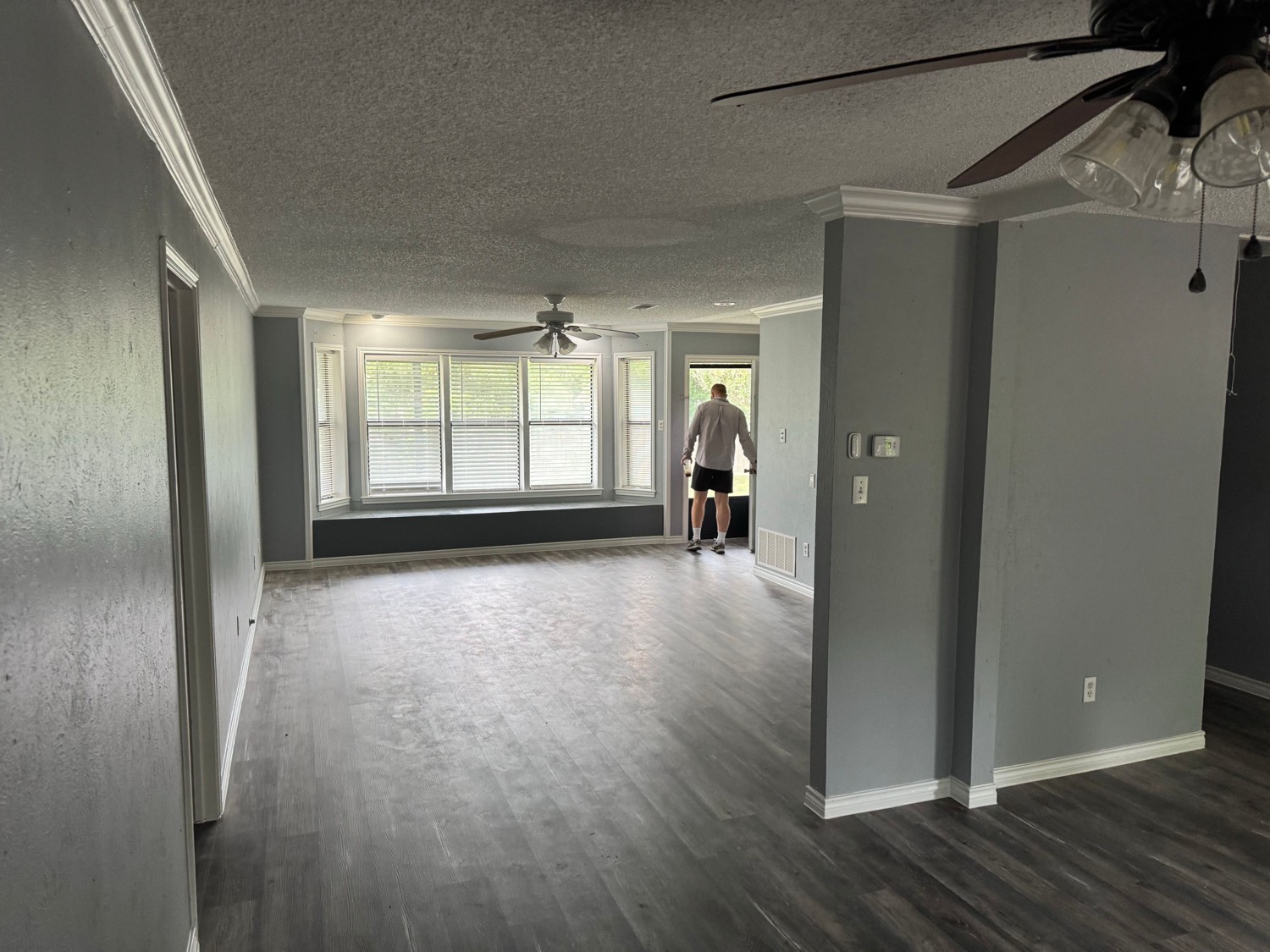 Spacious living room with bay window and wood-look floors